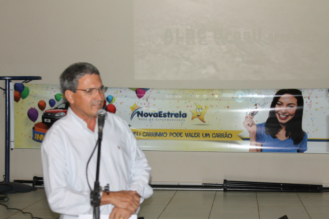 O líder do grupo Nova Estrela e ao fundo a faixa alusiva à promoção comemorativa aos 45 anos da empresa 