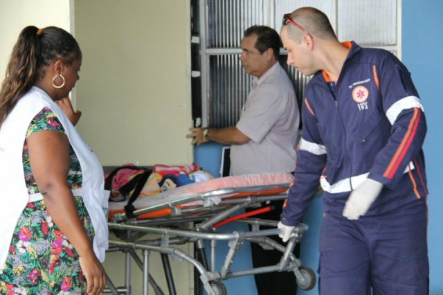 Socorrista do SAMU transporta o bebê para a viatura e depois o encaminha para o Centro de Saúde do bairro onde a criança foi abandonada (Foto: CG News)