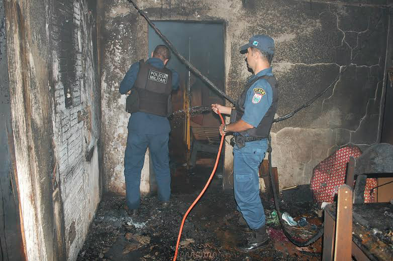Marido briga e bate na mulher e depois ateia fogo na casa Com baldes e mangueira, os policiais militares controlaram o incêndio na casa já quase toda consumida pelas chamas (Foto: Divulgação)