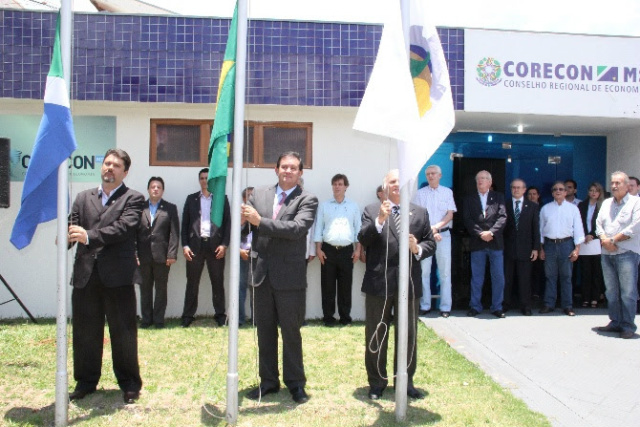 Deputado Eduardo Rocha é homenageado pelo CORECON/MS Eduardo Rocha desfraldou a Bandeira Nacional e depois agradeceu a homenagem e falou sobre a importância do economista para a sociedade e para o sucesso de uma nação (Foto: Divulgação)