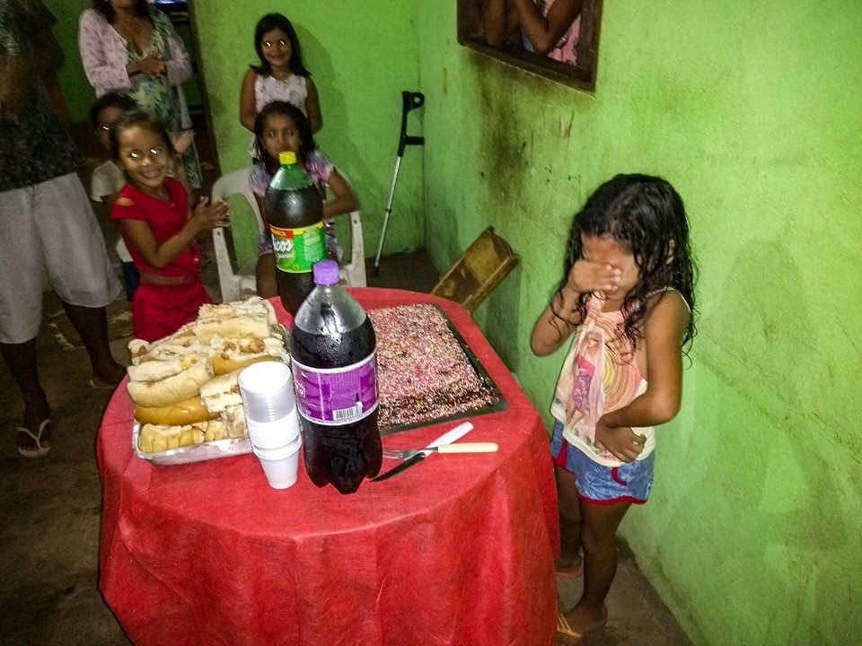 Garota chora de emoção com bolo de aniversário; foto repercutiu (Reprodução/Facebook).