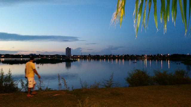 Um dos frenquentadores contempla o por do sol na Lagoa Maior, tendo ao fundoo edifício Ramez Tebet (Foto: Ricardo Ojeda)