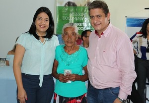 Elisa Cleia, dona Adelcida e prefeito Ascoli na entrega do documento, durante ação em Sidrolândia.

