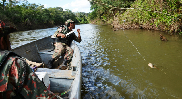 Policiais tirando anzol de galho com peixe-capa. (Foto: Divulgação)