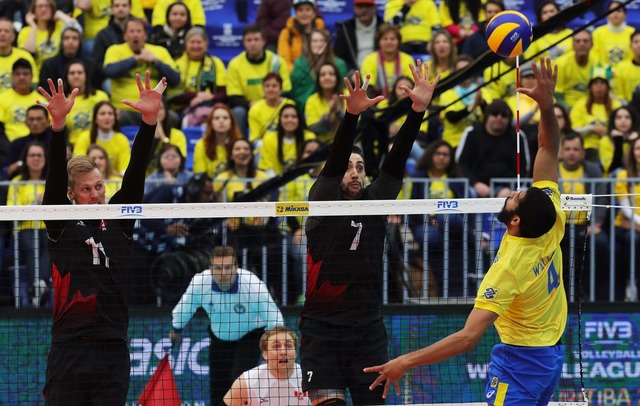 No frio de Curitiba, Brasil demora a aquecer, mas bate o Canadá na estreia Wallace ataca diante do bloqueio canadense (Foto: Divulgação/FIVB)