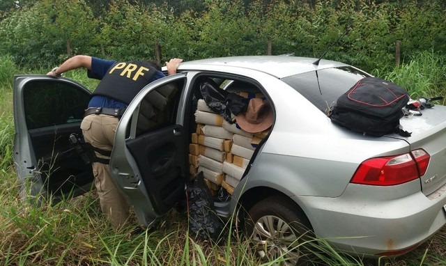 Carro locado em MG é apreendido em MS lotado de cocaína, maconha e skank Carro lotado de drogas foi deixado em mato às margens de rodovia em MS (Foto: PRF/Divulgação)