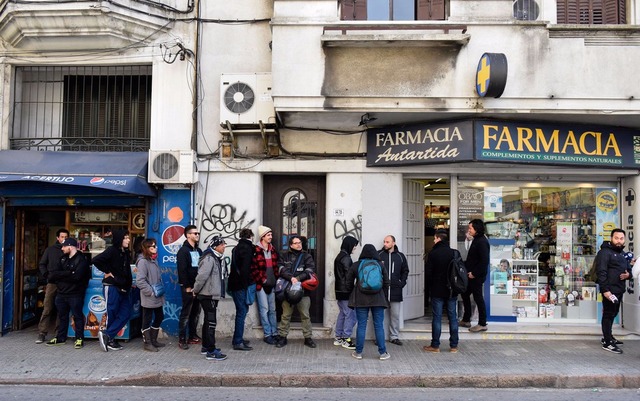 Compradores cadastrados fazem fila para comprar maconha legal em farmácia de Montevidéu, no Uruguai, no primeiro dia de vendas, na quarta (19) (Foto: AP Photo/Matilde Campodonico)