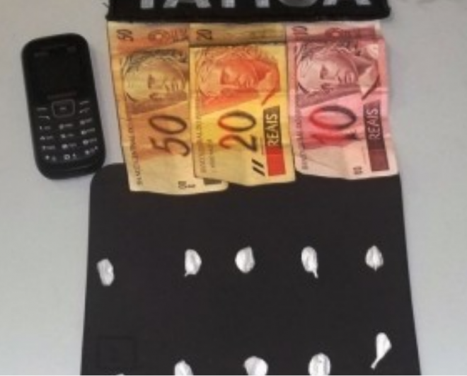 Na busca pessoal foram localizados com ele R$ 80 e também dez porções de cocaína dentro de sua carteira (Foto: Nova News)