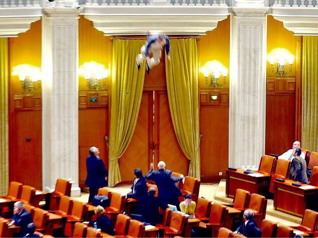 ...e pula sobre as cadeiras do Parlamento em protesto contra cortes do governo, em Bucareste (Foto: AP)
