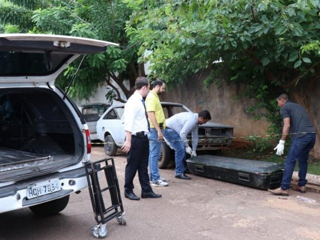 Estrangulado com corda e degolado, corpo é achado atrás de escola Agentes da funerária recolhem corpo de homem encontrado em calçada de escola (Foto: Henrique Kawaminami)