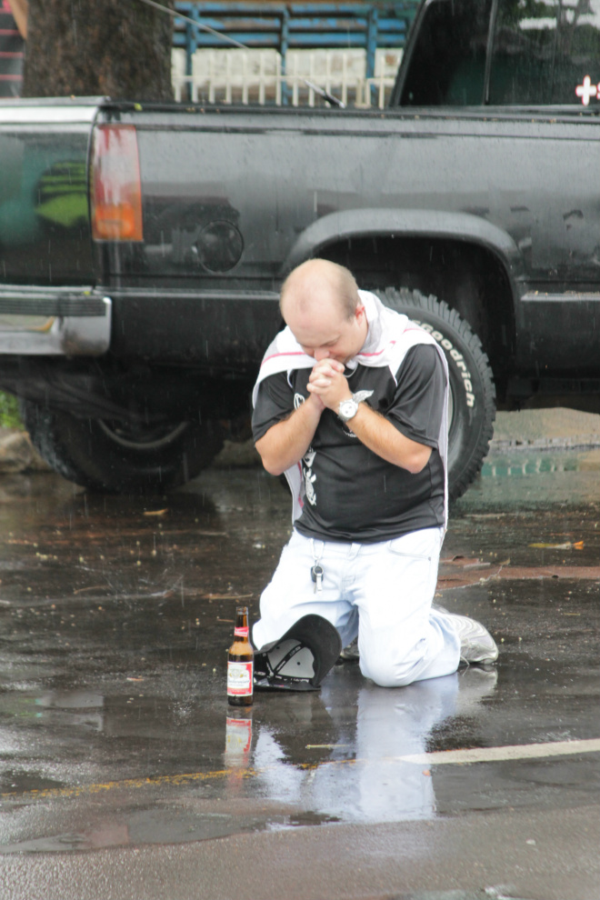 Torcedor paga promessa de joelhos na avenida