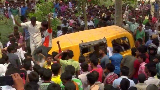 Pessoas se reúnem em volta de van escolar atingida por trem na Índia Foto: HANDOUT / REUTERS
