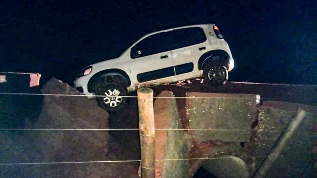 Carro cai em buraco aberto pela chuva e família fica presa na área rural de Três Lagoas Carro ficou preso no enorme buraco aberto pela enxurrada. Foto: Divulgação Corpo de Bombeiros.