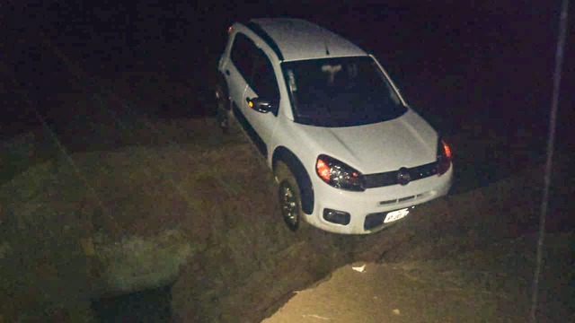 Carro cai em buraco aberto pela chuva e família fica presa na área rural de Três Lagoas Carro ficou preso no enorme buraco aberto pela enxurrada. Foto: Divulgação Corpo de Bombeiros.