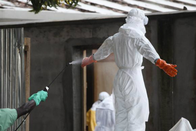 Enfermeiro da Libéria passa por descontaminação após ter contato com corpos de vítimas do ebola (FOTO: Agência Brasil)