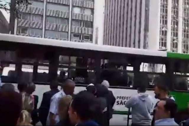 Passageiros e transeuntes aguardam a prisão do homem ao lado de ônibus, na Avenida Paulista. (Foto:Reprodução / G1)