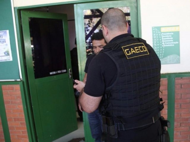 Agente do Gaeco entrando na ala das diretorias do Detran-MS, que foi vasculhada (Foto: Marcos Ermínio)