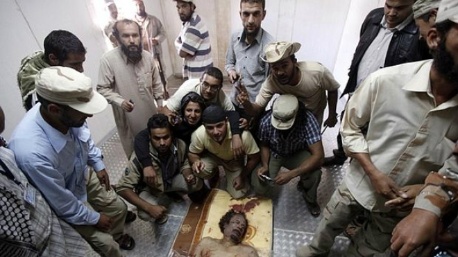 Combatentes disputam espaço para tirar foto ao lado do corpo de Kadhafi (Foto:Saad Shalash/Reuters)