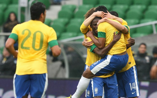 Jogadores comemoram com Paulinho o primeiro gol no amistoso na Polônia (Foto: Mowa Press)