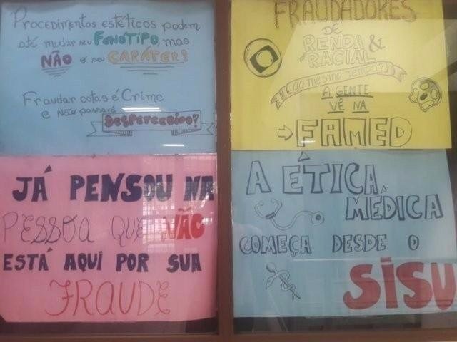 Mais 5 acadêmicos da UFMS obtêm liminares e voltam a cursar Medicina Cartaz pregado em meio a denúncias sobre possível fraude em sistema de cotas; sete alunos excluídos conseguiram liminares para continuar na UFMS. (Foto: Arquivo)