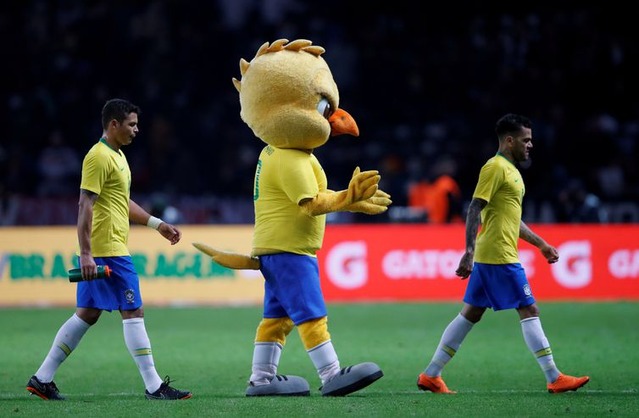 O mascote da seleção canarinho e os jogadores - REUTERS/Wolfgang Rattay