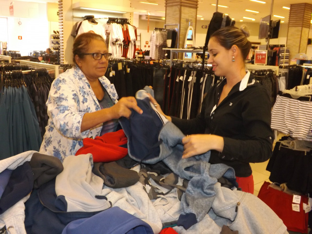 A gerente de vendas ajuda à consumidora a escolher roupas de frio para os netos. (foto: Fábio Jorge)