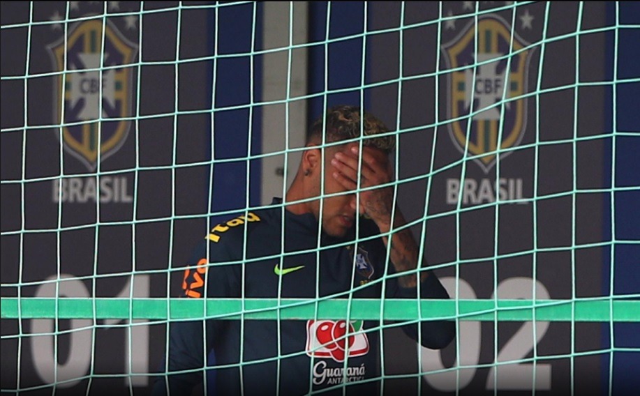 Neymar sofre com dores e deixa treino da seleção mancando Neymar coloca a mão no pé antes de deixar treino da seleção brasileira - Imagem: MoWA Press