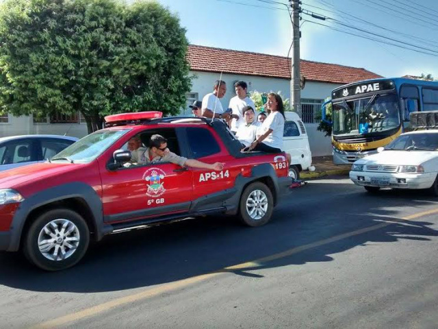 Na carroceria de viatura do Corpo de Bombeiros, André e o técnico Roney desfilam na carreta pela cidade (Foto: Divulgação)
