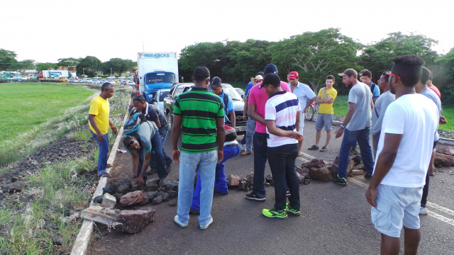 Trabalhadores de outras empresas retiram as pedras que impediam a passagem de veículos e por pouco não chegaram às vias de fatos com os manifestantes (Foto: Ricardo Ojeda)