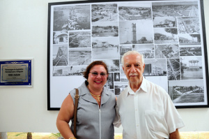 Jamile Zaguir com o tio e ao fundo o painel com fotografias históricas de Três Lagoas captada pelo seu pai