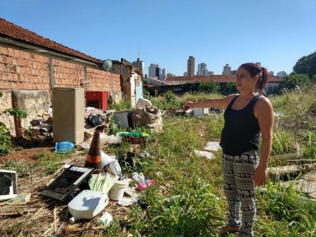Moradora mostra sujeira em terreno baldio. (Foto: Liniker Ribeiro)
