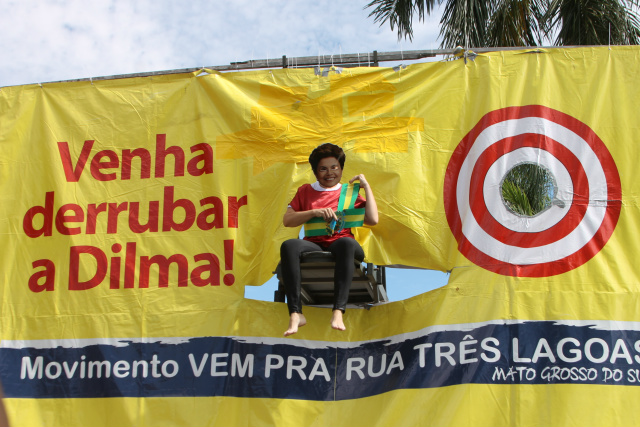 Ação “Derruba Dilma” reúne manifestantes em Feira Livre de Três Lagoas Um manifestante representando a presidente Dilma Rousseff era derrubado em uma brincadeira realizada durante a ação (Foto: Daniela Silis)